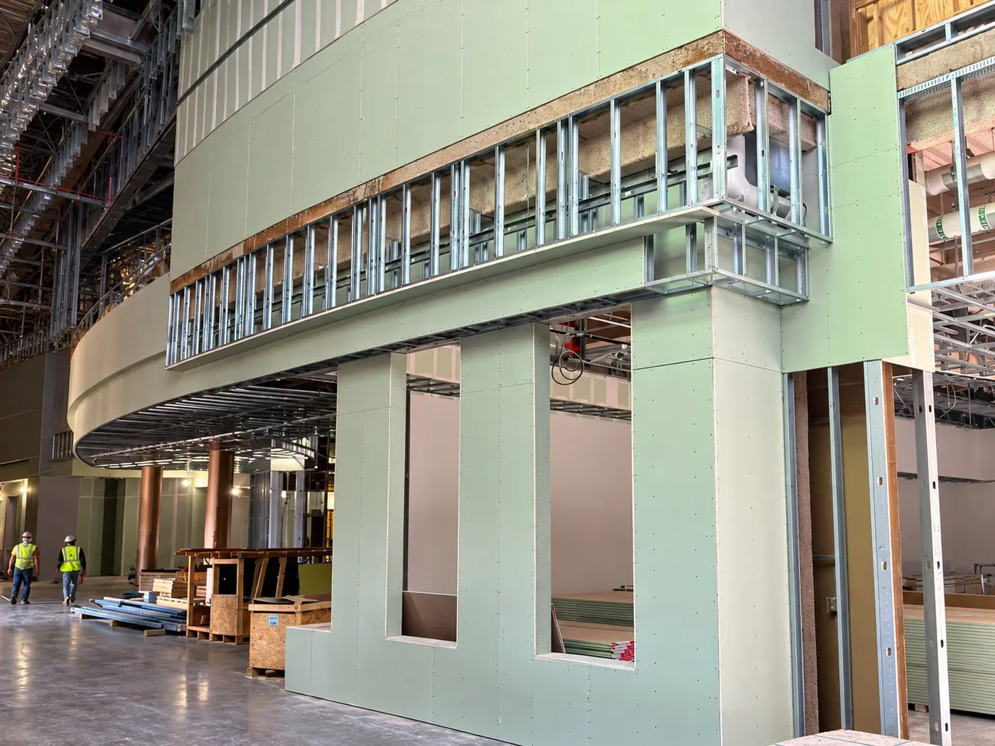 CCGroup moisture- and mold-resistant gypsum board hung on a multi-story atrium wall with framed openings, a curved soffit and stud framing above