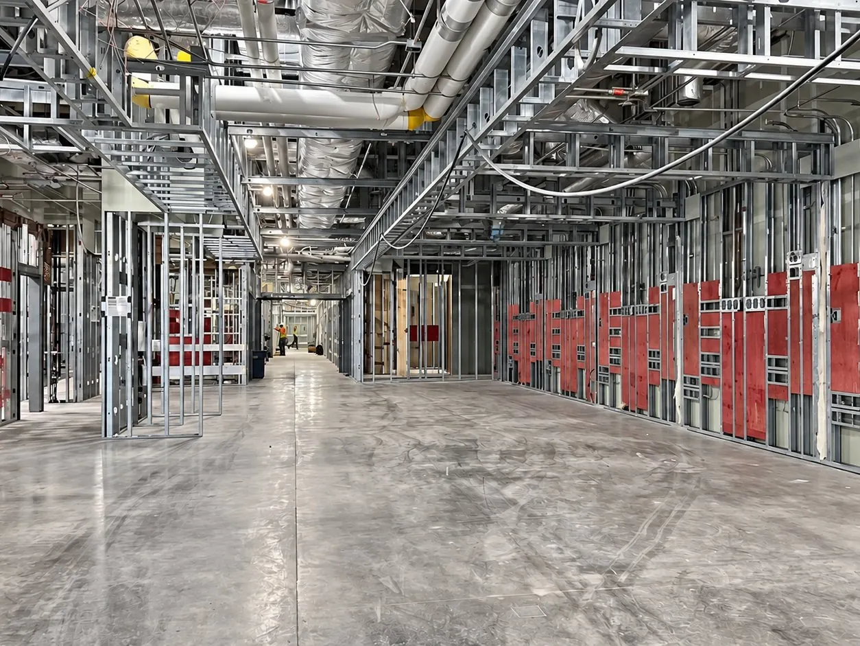 CCGroup full-height metal stud framing with fire-retardant blocking and framed ceiling soffits along a hospital corridor